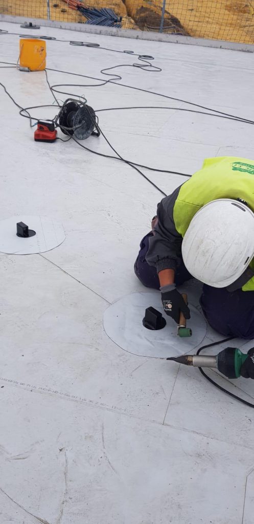 Operario instalando piezas FYT Waterfix en una cubierta impermeabilizada